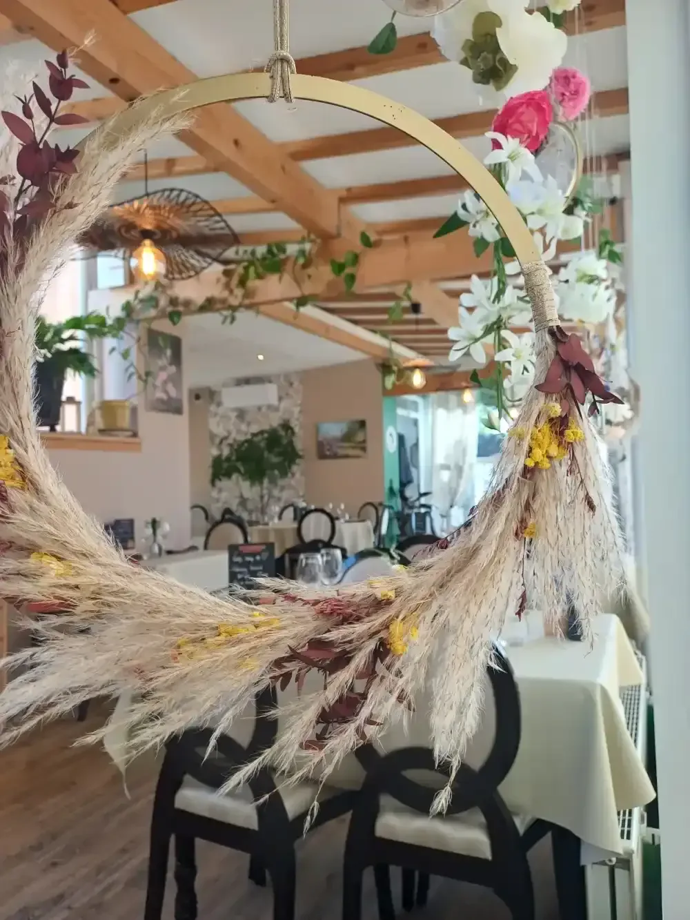 Couronne de pampas suspendue au-dessus de la salle — Au Petit Gourmet