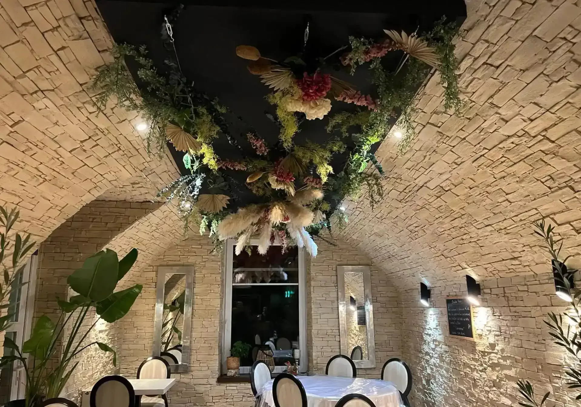 Salle du restaurant Au Petit Gourmet — voûtes en pierre et décor floral suspendu